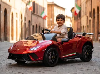 Voiture de course électrique enfant Lamborghini Huracán 12V rouge, garçon au volant dans une rue pavée italienne