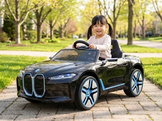 BMW i4 enfant 12V noir, scène jardin avec enfant