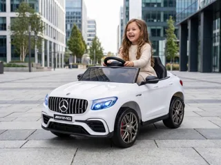 Mercedes GLC 63 AMG 12V blanc, enfant au volant sur une place urbaine, trois-quarts avant
