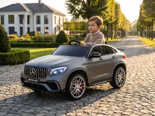 Mercedes GLC 63 AMG 12V gris mat, enfant au volant sur une allée pavée devant une villa