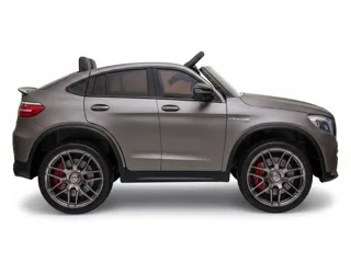 Mercedes GLC 63 AMG 12V gris mat, profil latéral, lignes de SUV coupé et jantes AMG, fond blanc studio