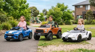 Voiture électrique enfant Ford : trois modèles alignés, Mustang Mach-E bleue, Raptor F-150 orange et Ford GT blanche, conduits par des enfants dans un parc