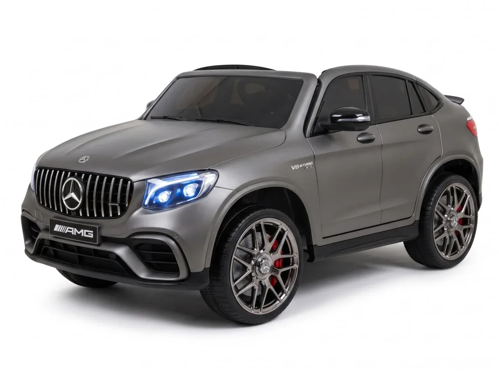 Mercedes GLC 63 AMG 12V gris mat, enfant installé au volant, trois-quarts avant, fond blanc studio
