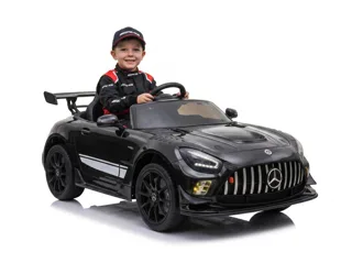 Mercedes-AMG GT3 12V noir, enfant souriant en tenue de pilote au volant, fond blanc studio